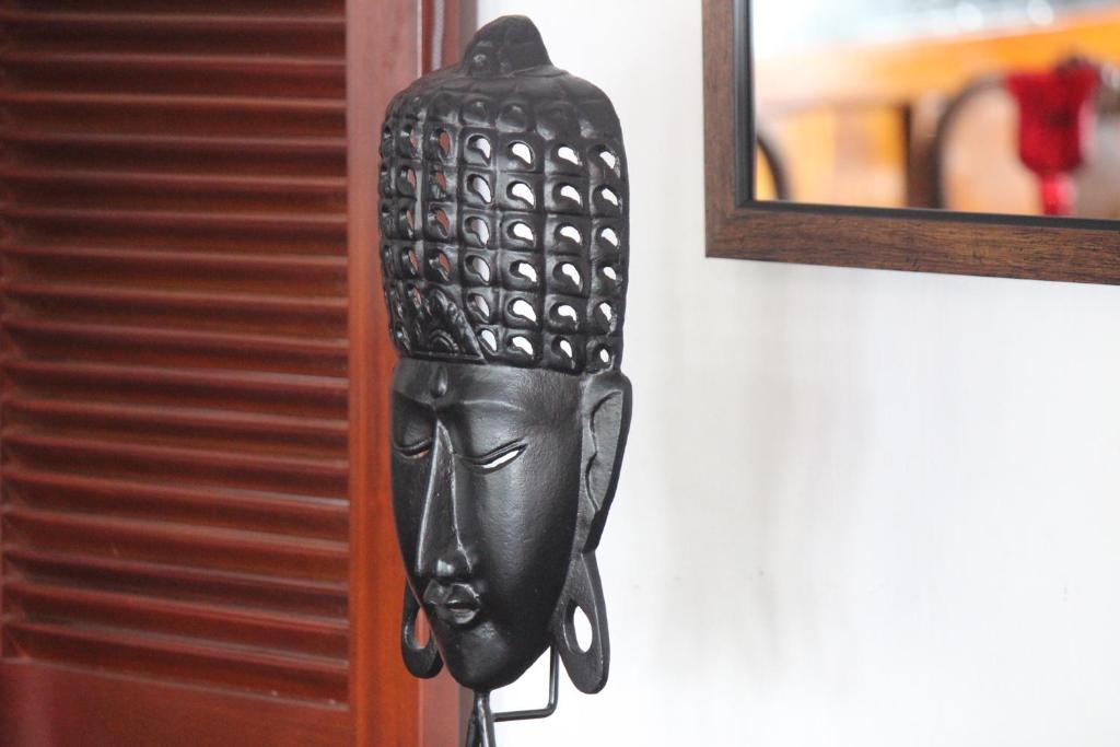 a black door knocker hanging on a wall at Selyna Sky Terrace in Kandy