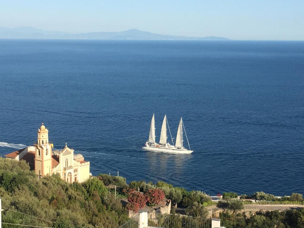 łódź z dwoma żaglami w wodzie blisko zamku w obiekcie Blue Dream - Amalfi Coast w mieście Conca dei Marini