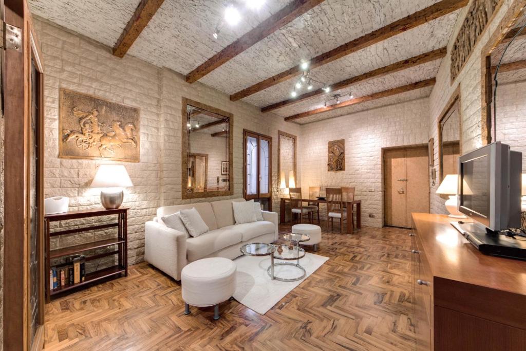 a living room with a couch and a tv at Fontana di Trevi Charming Apartment in Rome