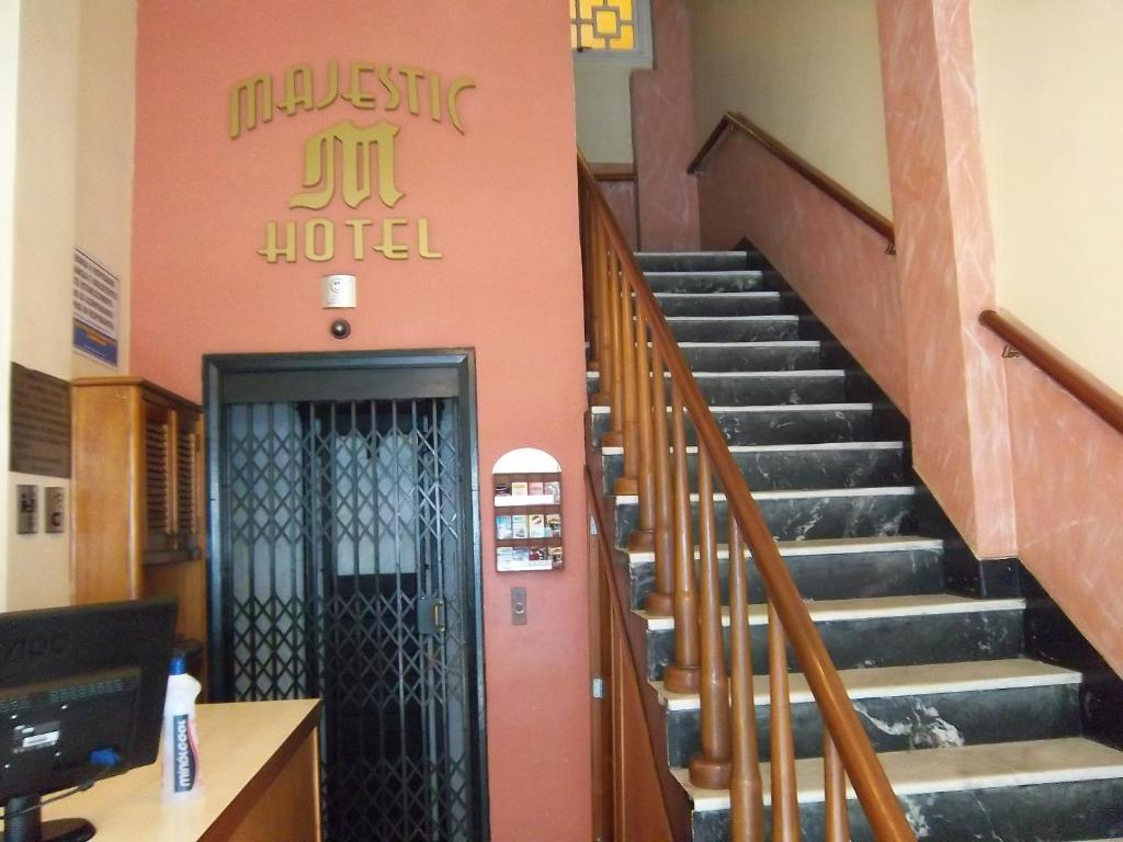 eine Lobby mit einer Treppe in einem Krankenhaus mit einer Tür in der Unterkunft Majestic Hotel in Juiz de Fora