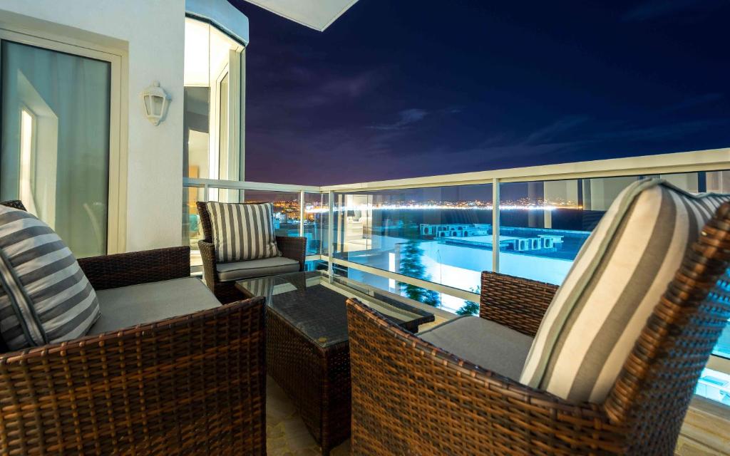 a balcony with chairs and a swimming pool at night at Hotel Farah Tanger in Tangier