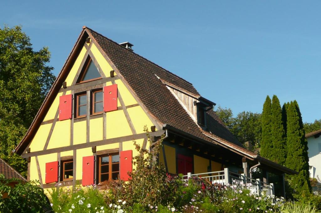 une maison avec de la peinture rouge et jaune dans l'établissement La Pomme de Pin, à Raedersdorf