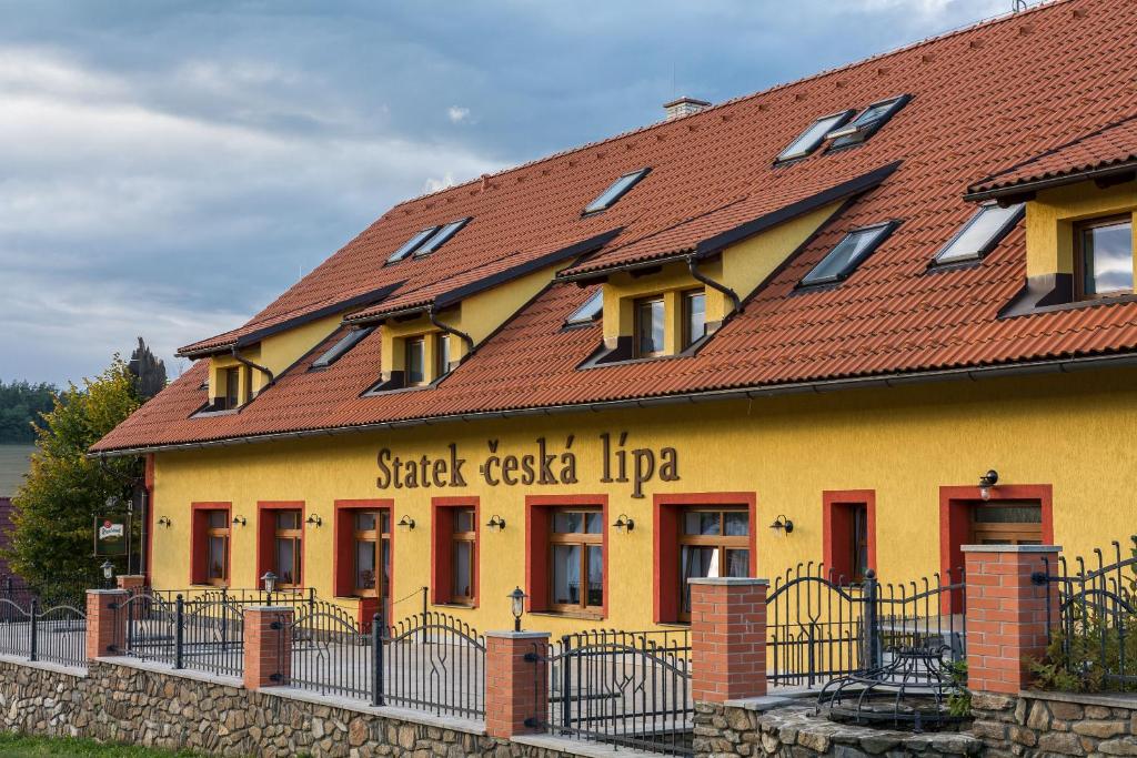 um edifício amarelo com um telhado vermelho em Statek česká lípa Myslovice em Klatovy