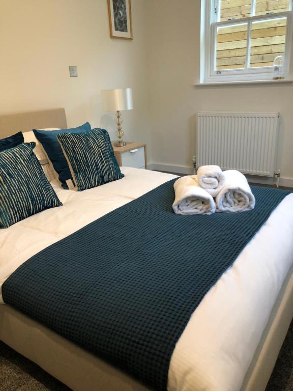 two towels on a bed in a bedroom at Portfolio Apartments - St Albans City Centre in St. Albans