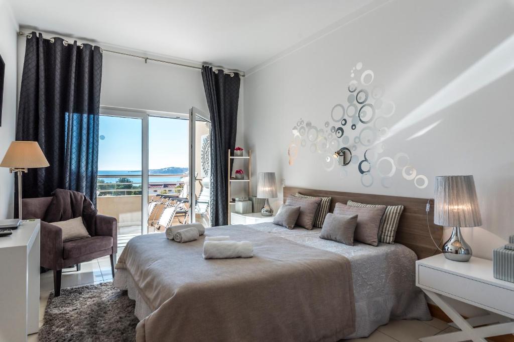 een witte slaapkamer met een groot bed en een balkon bij Beachfront flat, private parking, pools, sea at less than 200 m in Albufeira