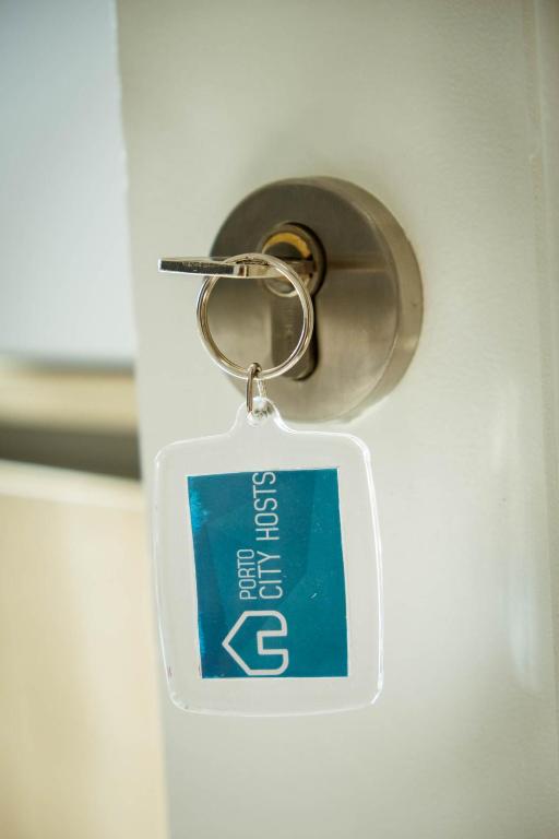 a key chain with a sign attached to a door at Almada Story Apartments by Porto City Hosts in Porto