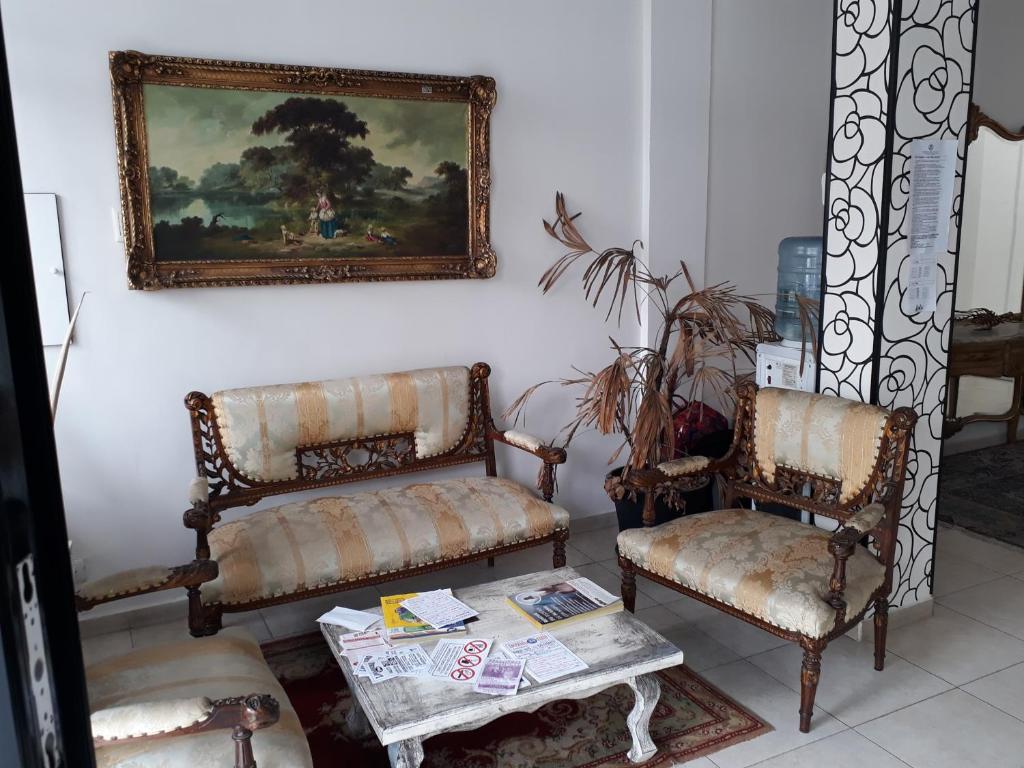 una habitación con 2 sillas y un cuadro en la pared en Lolo Hotel Boutique en Mar del Plata