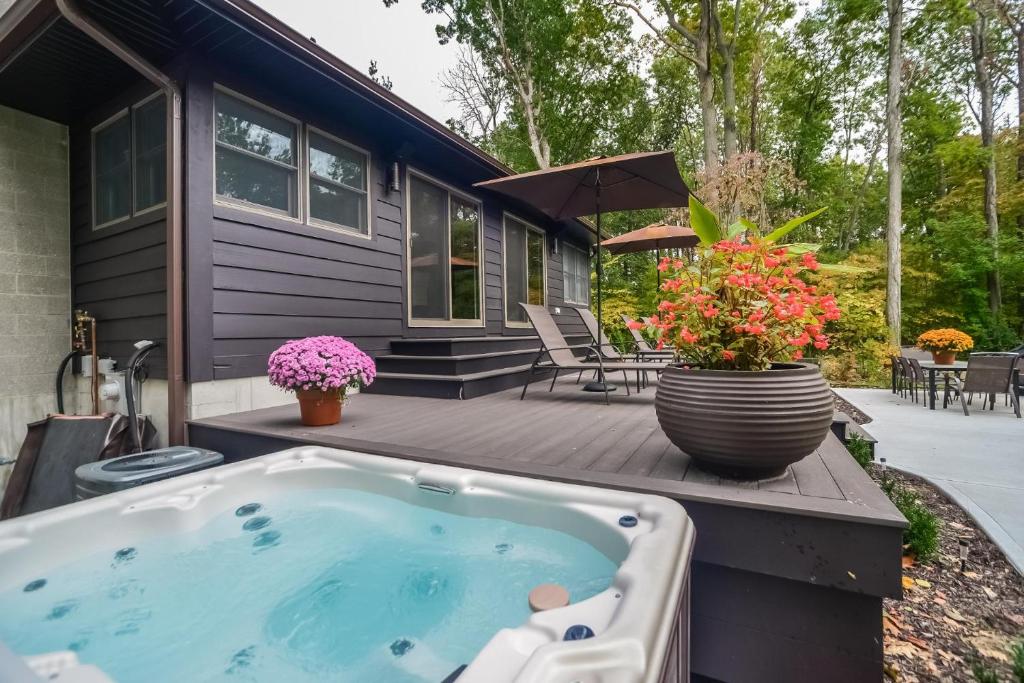 una pequeña casa azul con bañera de hidromasaje en una terraza en Rivers Edge, en Saugatuck