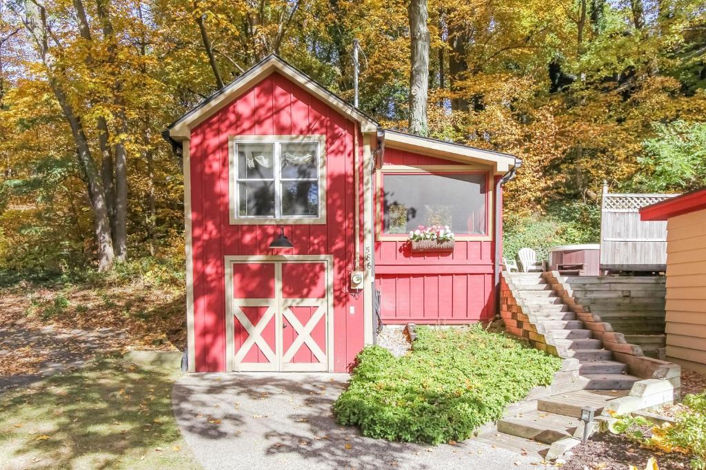 um barracão vermelho com uma porta e uma janela em The Oriole em Saugatuck