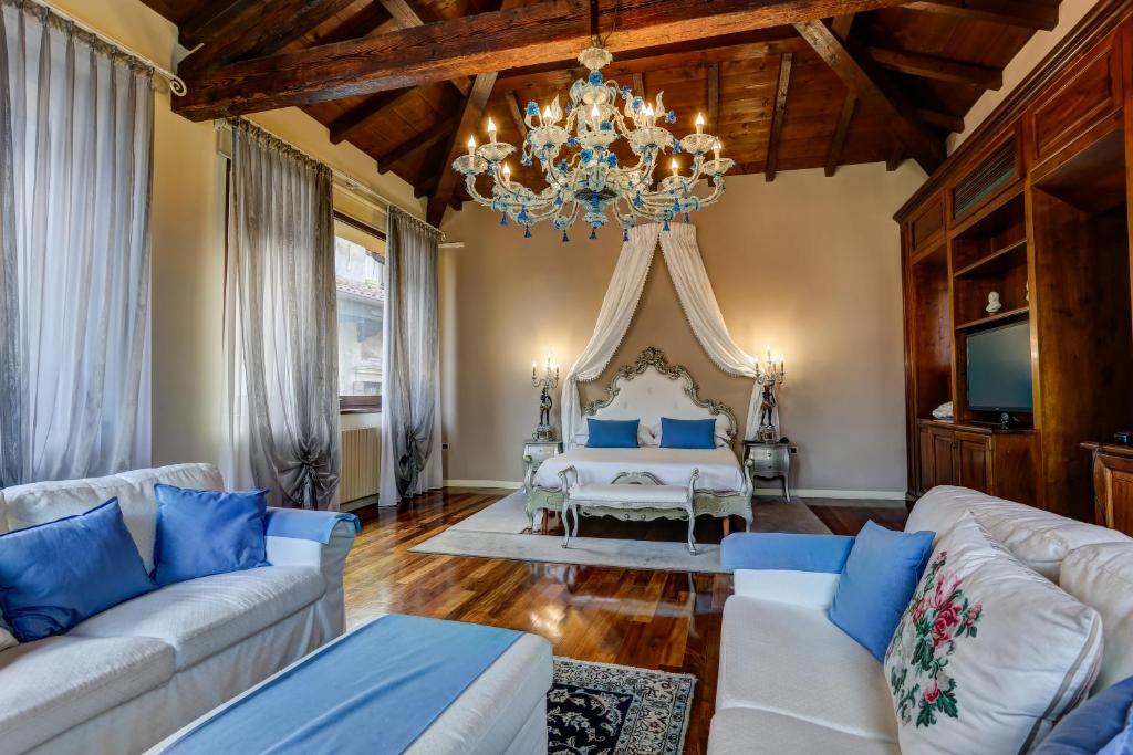 a living room with a bed and a chandelier at Relais Ponte Pietra in Verona