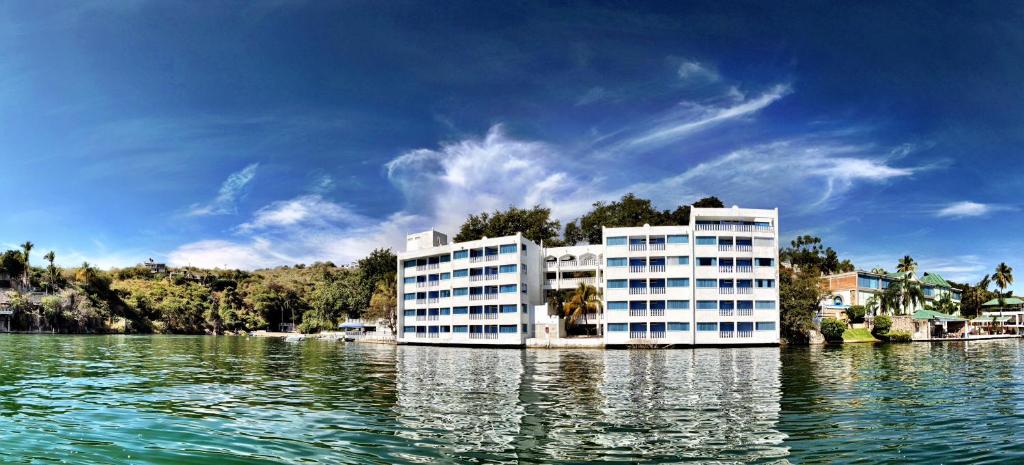 a large white building on the water on a lake at Villa Bejar Tequesquitengo in Tequesquitengo