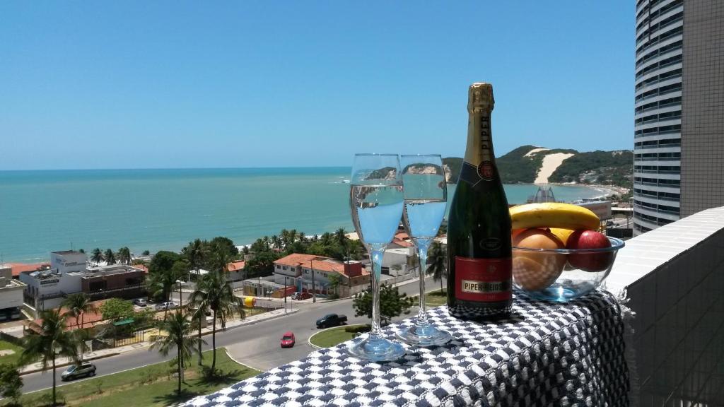 una bottiglia di vino e bicchieri su un tavolo sul balcone di Natal Prime - Porto Imperial a Natal