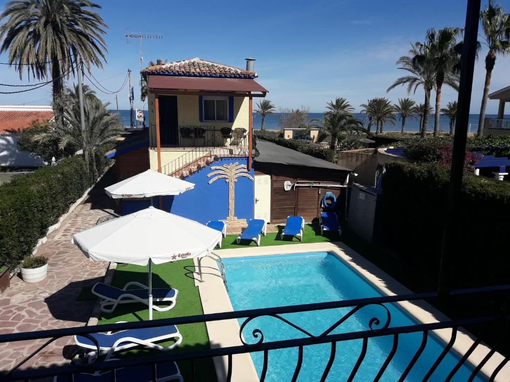a house with a pool and a balcony at Hostal Oasis in Denia