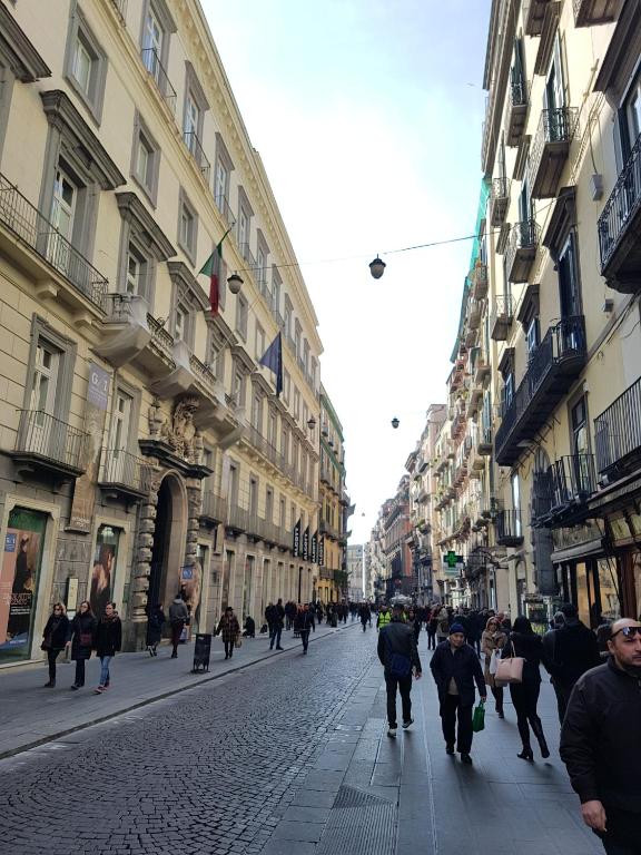 grupa ludzi idących ulicą z budynkami w obiekcie B&B NAPOLI AMORE MIO w mieście Neapol