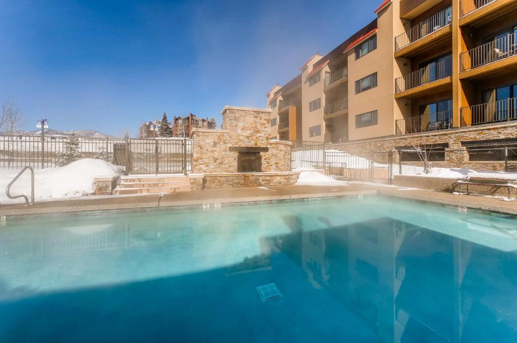 a large swimming pool in front of a building at Snow Flower Condos in Steamboat Springs