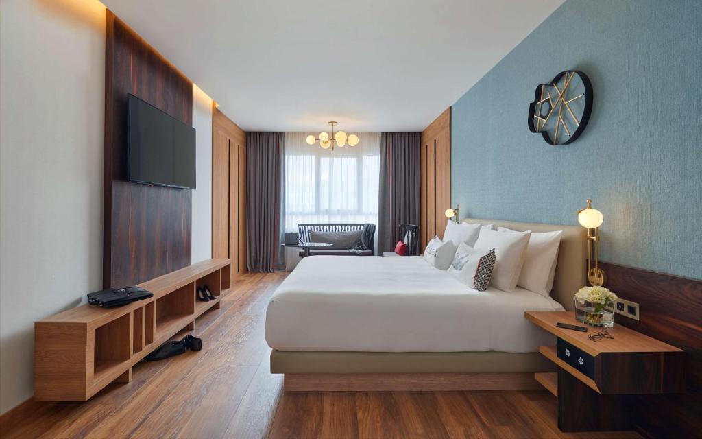 a living room with a large bed and a television at Hyatt Centric Gran Via Madrid in Madrid