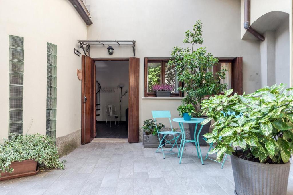 a patio with a table and chairs and plants at Violino azul in Cremona