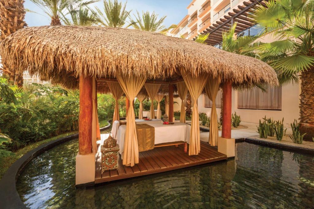 a bed in a hut next to a pool at Hyatt Ziva Los Cabos - All Inclusive in San José del Cabo