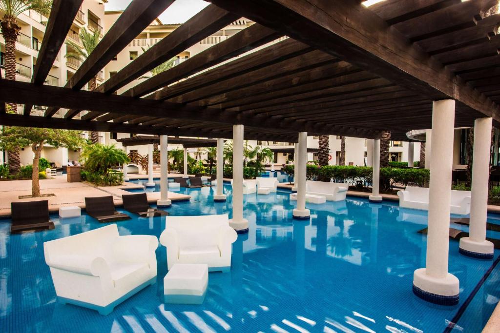 a resort pool with white chairs and tables at Hyatt Ziva Los Cabos - All Inclusive in San José del Cabo