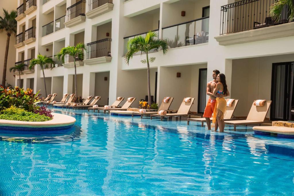 a pool at a hotel with people standing next to chairs at Hyatt Ziva Los Cabos - All Inclusive in San José del Cabo