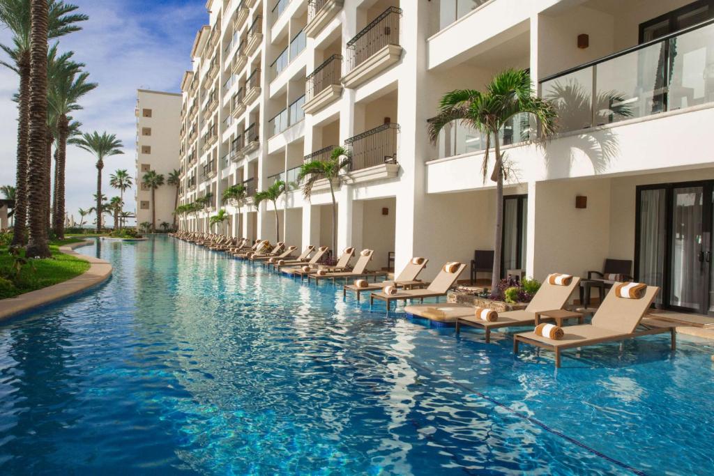 a hotel swimming pool with lounge chairs in front of a building at Hyatt Ziva Los Cabos - All Inclusive in San José del Cabo