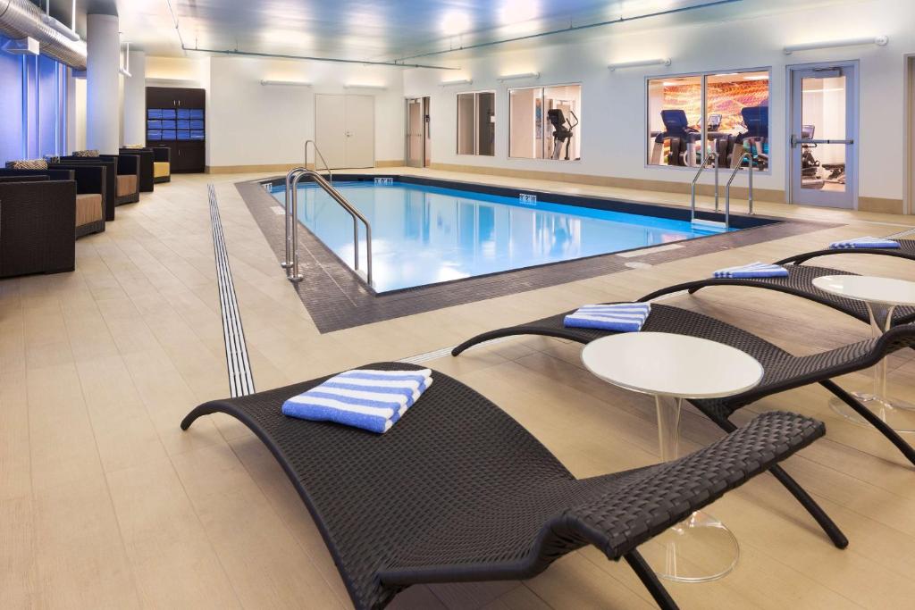a swimming pool with tables and chairs in a building at Hyatt Regency Bloomington - Minneapolis in Bloomington