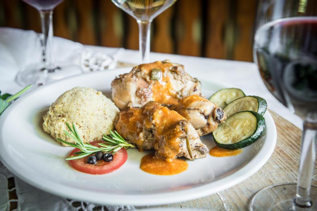 a plate of food with chicken and vegetables on a table at Albergo Cinzia in Vattaro