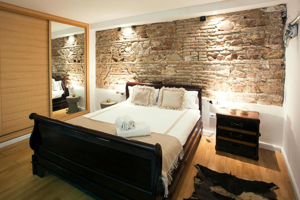 マラガにあるQuiet & Exclusive Apartment Historic Centerのレンガの壁、ベッド付きのベッドルーム1室
