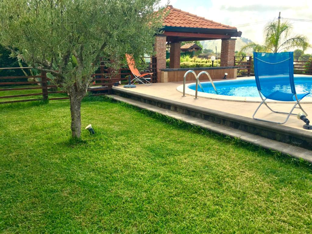 un cortile con una sedia blu e una piscina di Dependance in villa, Etna, natura, relax a Nicolosi