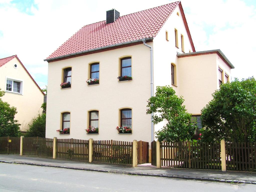 ein weißes Haus mit einem Zaun in der Unterkunft Ferienwohnung Grimma in Grimma