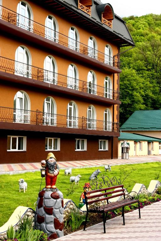 a large building with a statue in front of a building at Perlyna Podillyа in Satanov