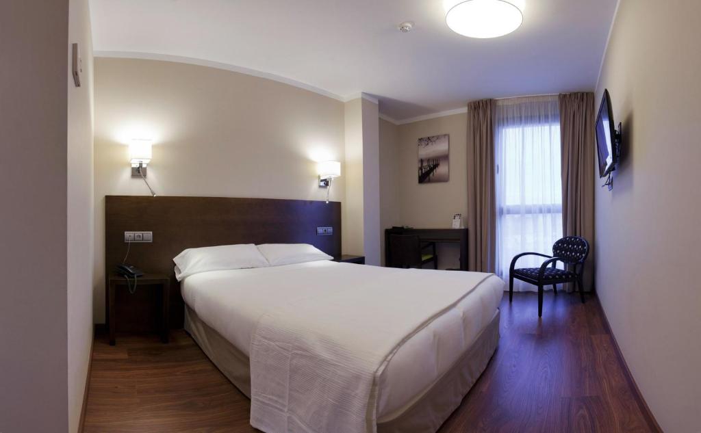 a hotel room with a large bed and a window at Hotel Río Hortega in Valladolid