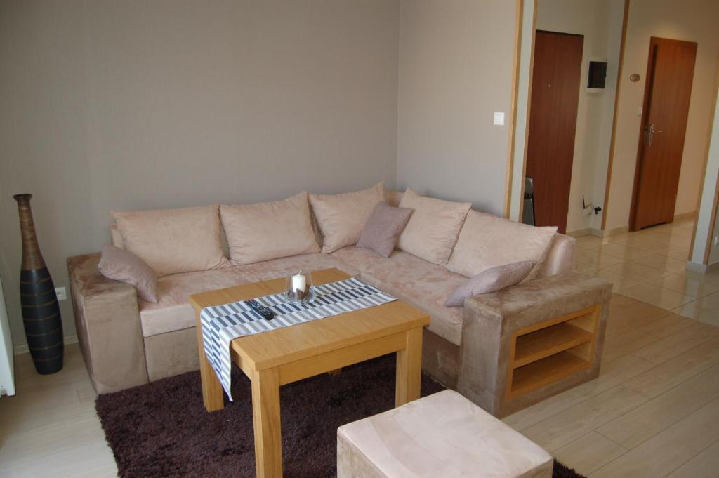 - un salon avec un canapé et une table dans l'établissement Apartamenty Plaza Słupca, à Słupca