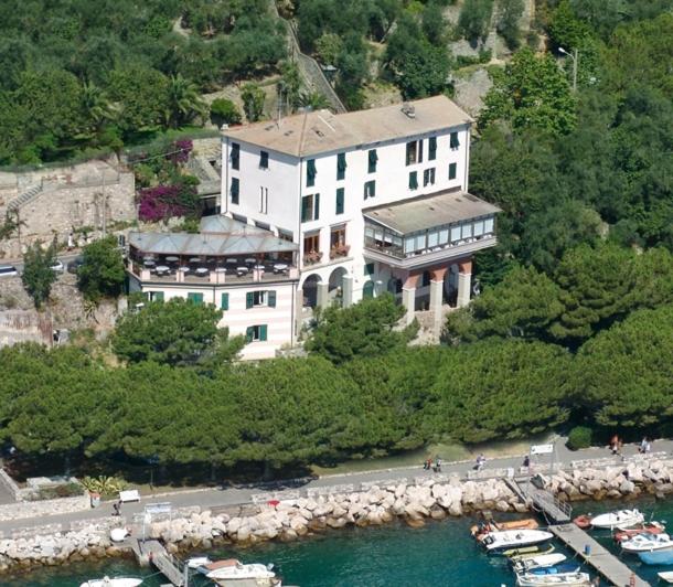a large white building on the side of a river at Albergo Ristorante Paradiso in Portovenere
