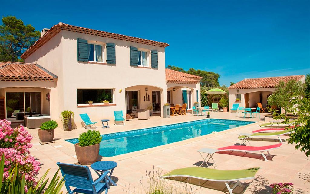 een villa met een zwembad en tuinmeubilair bij Le Mas Pinède in Lorgues