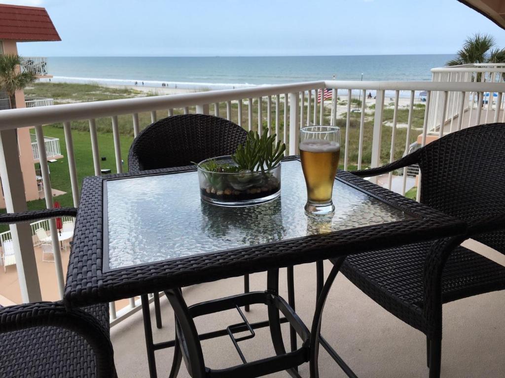 un vaso de cerveza sentado en una mesa en un balcón en Spanish Main en Cocoa Beach