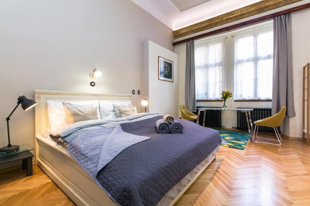 a bedroom with a bed and a table with chairs at Apartment Nebovidy I - Free Parking - Terrace - Air Conditioning in Prague