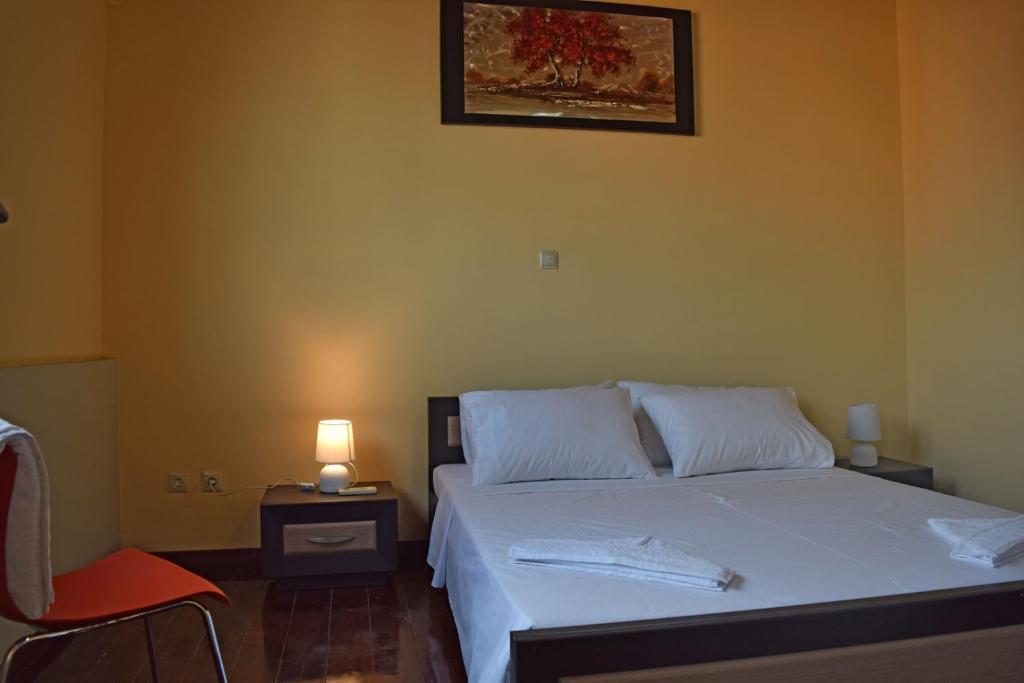 Kalamítsion AlexándrouにあるVenetian Cistern Villaのベッドルーム1室(ランプと椅子付きのベッド1台付)