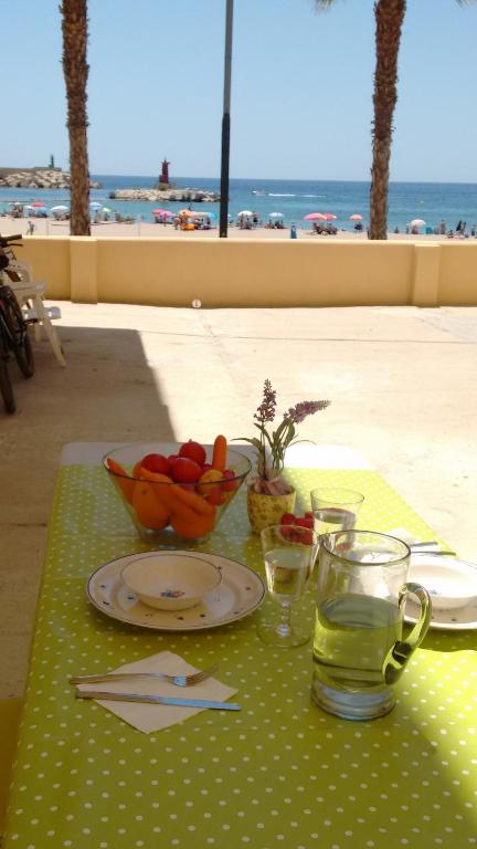 stół z talerzem jedzenia i miską owoców w obiekcie Playa centro w mieście Villajoyosa