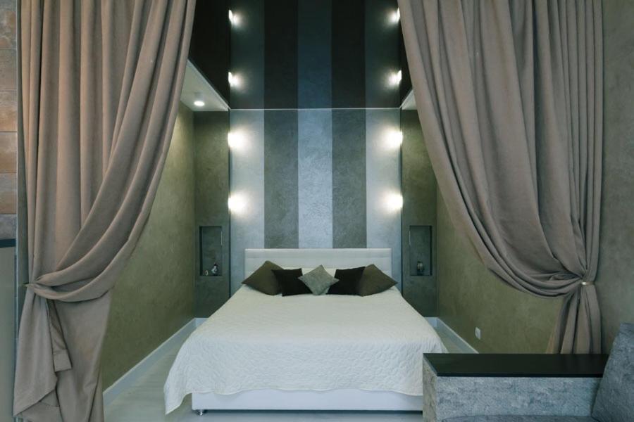 1 dormitorio con cama blanca y cortinas en Апартаменты Гмыри 12б, en Kiev