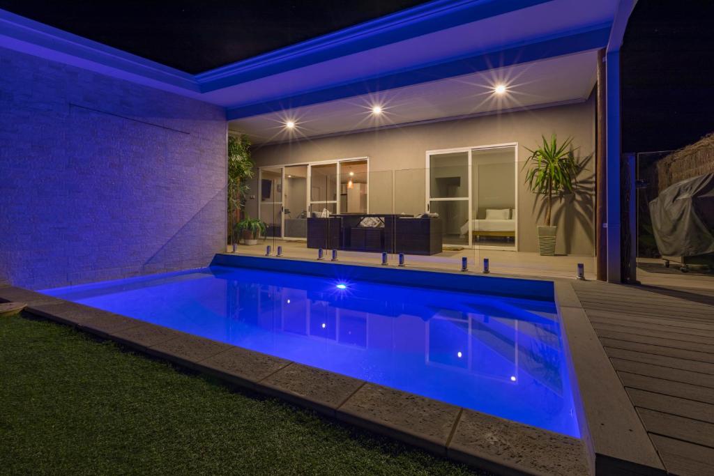 a swimming pool at night with a house in the background at Sols Place Boutique Pool Villas in Kalbarri