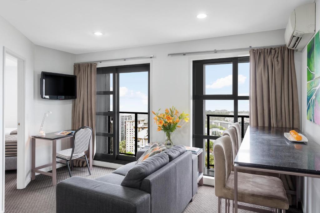 a living room with a couch and a table at Nesuto St Martins Apartment Hotel in Auckland