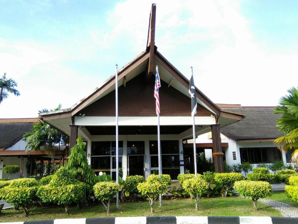 um edifício com duas bandeiras à frente em Motel Desa em Kuala Terengganu