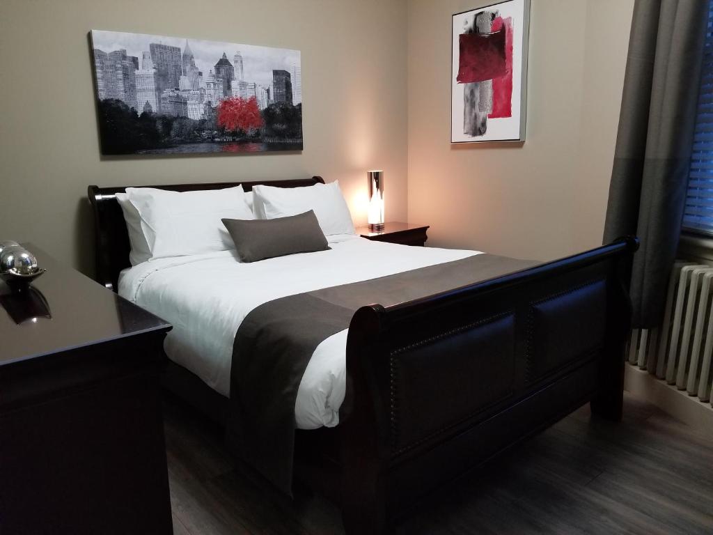 1 dormitorio con 1 cama grande con almohadas blancas en 1-Bedroom Cozy Suite #26 by Amazing Property Rentals, en Gatineau