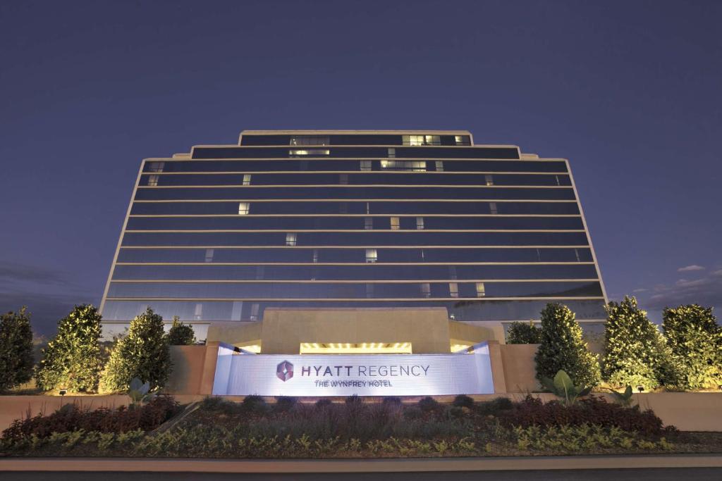 Hyatt Regency Birmingham - The Wynfrey Hotel في برمنغهام: مبنى طويل مع علامة أمامه