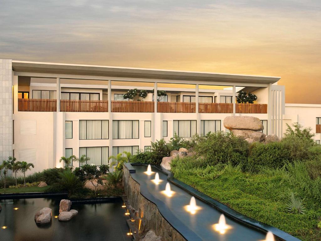 a rendering of a building with a river in front at Hyatt Hyderabad Gachibowli in Hyderabad