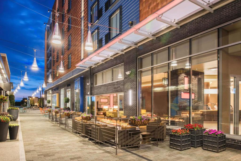 a building with tables and chairs on a street at Hyatt Place Cleveland/Westlake/Crocker Park in Westlake