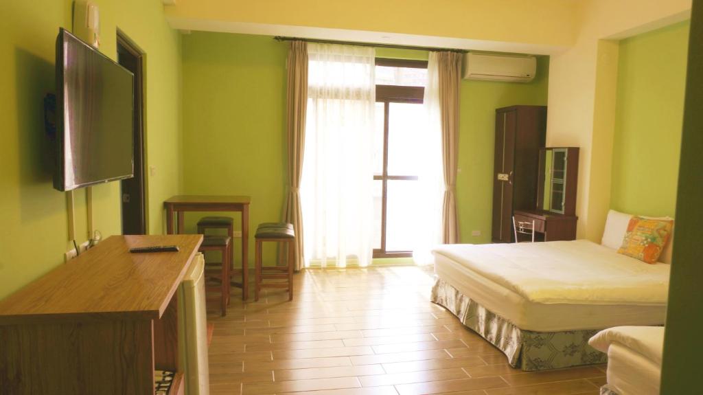 Habitación de hotel con 1 dormitorio con cama y TV en Warm Breeze Stay en Hualien
