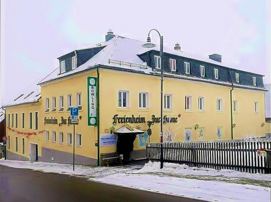 a yellow building on the side of a street at Ferienheim "Zur Krone" in Kurort Oberwiesenthal