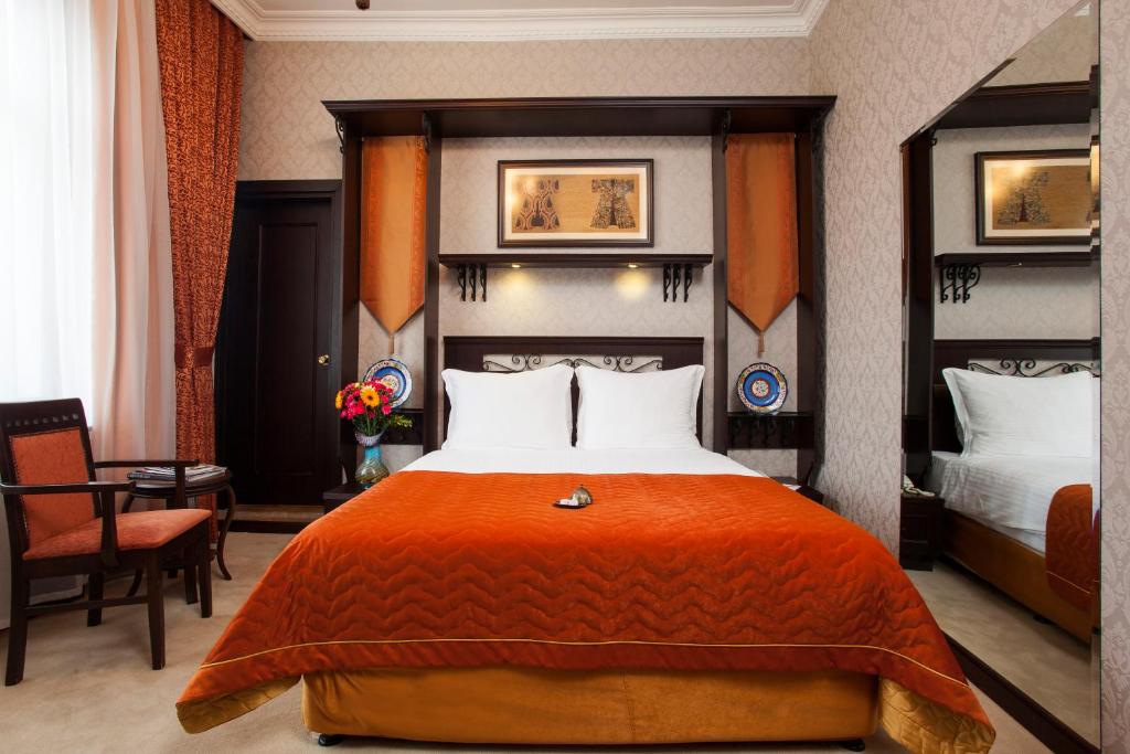 イスタンブールにあるオットマン ホテル インペリアル スペシャル カテゴリーのベッドルーム1室(大型ベッド1台、オレンジの毛布付)